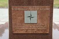 A close-up picture of the dedication plaque that reads "knowledge is the pole star" and "this obelisk is dedicated to instructor personnel of the Air Training Command, 7 July 1971."
