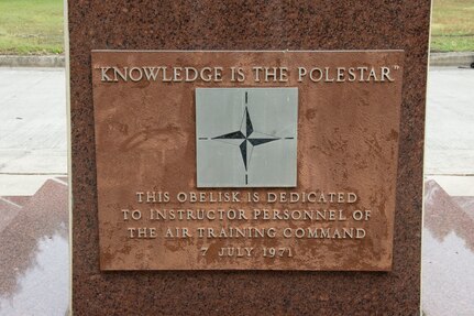 A close-up picture of the dedication plaque that reads "knowledge is the pole star" and "this obelisk is dedicated to instructor personnel of the Air Training Command, 7 July 1971."