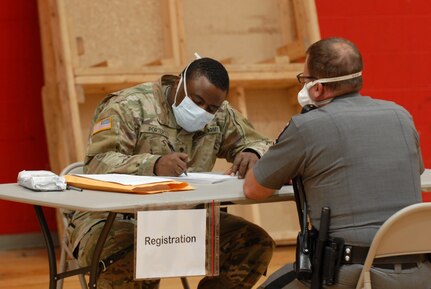 Army National Guard Spc. Matthew Porter, assigned to D Company, 427th Brigade Support Battalion, collects information from a member of the New York State Police at a COVID-19 antibody testing site in Williamsville, New York, May 5, 2020. Wedgwood and other members of the New York National Guard are supporting state agencies at antibody testing sties across New York.