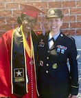 Future Soldier dressed in graduation cap and gown poses with female Soldier, Sgt. Mort, who is wear her Army dress uniform.