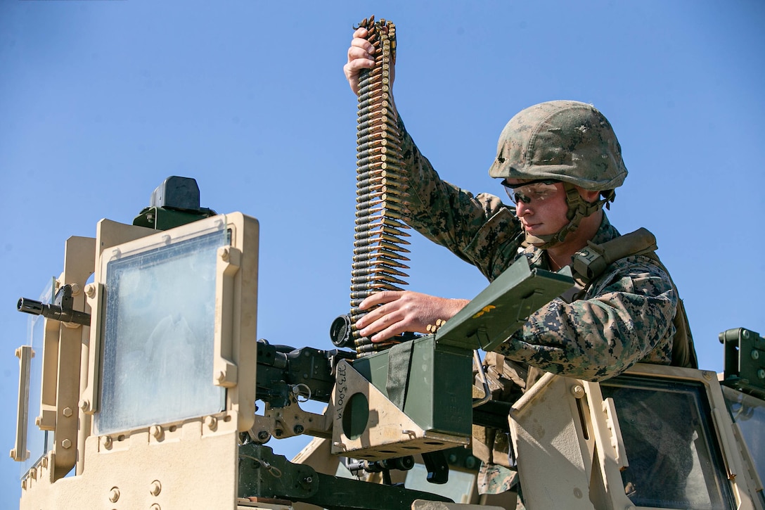 A U.S. Marine loads 7.62 mm ammunition into an M240B machine gun during a live-fire range part of a field exercise at Camp Lejeune, North Carolina, May 7, 2020.