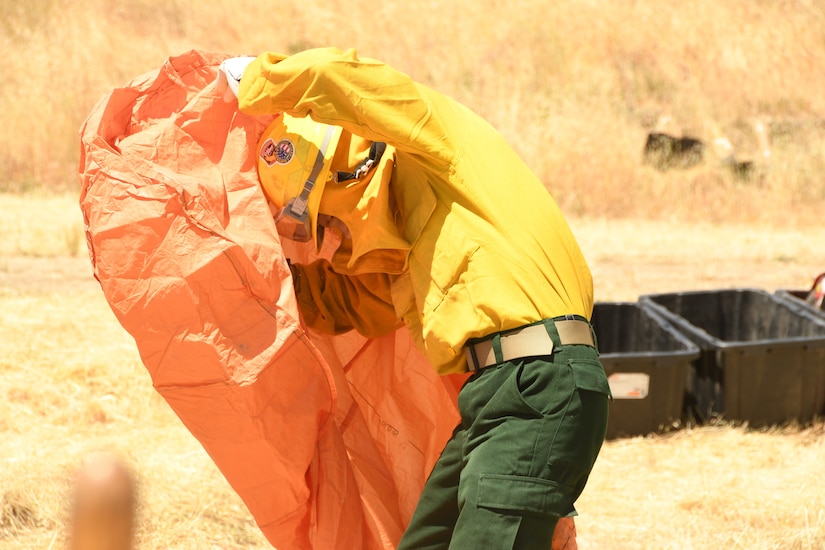 A soldier works on erecting a small tent.
