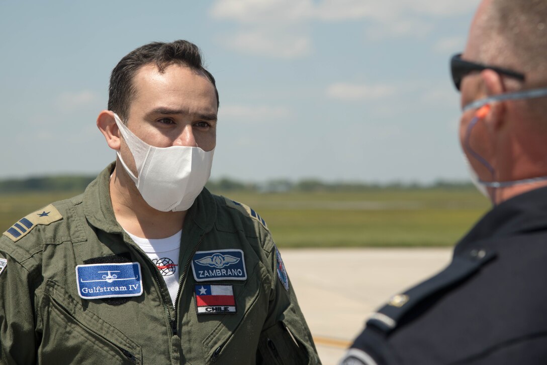 A Chilean Air Force member speaks to a U.S. Customs and Border Protection member May 13, 2020, at Dover Air Force Base, Delaware. The U.S. Air Force and the Chilean Air Force continue the partnership throughout the battle against COVID-19. The Chilean Air Force made a stop in a Gulfstream IV to unload and load cargo, sharing inventory between partner nations. (U.S. Air Force photo by Airman 1st Class Faith Schaefer)