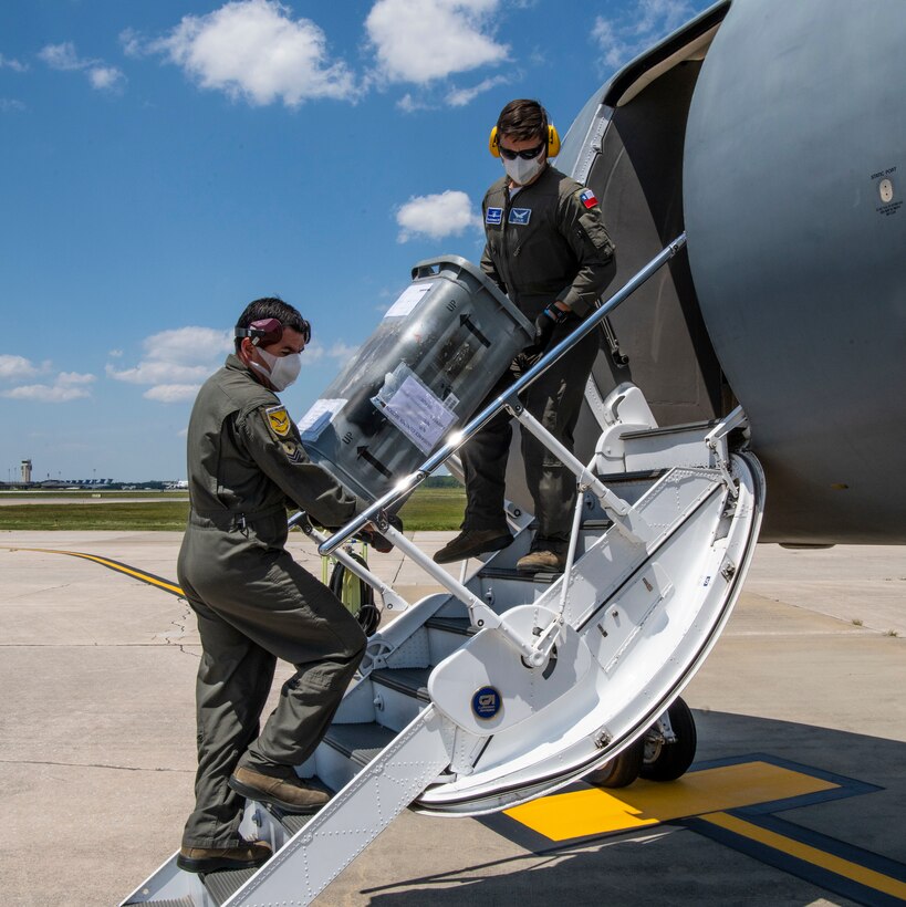 Two Chilean Air Force members unload inventory from a Gulfstream IV May 13, 2020, at Dover Air Force Base, Delaware. The U.S. Air Force and the Chilean Air Force continue the partnership throughout the battle against COVID-19. The Chilean Air Force made a stop in a Gulfstream IV to unload and load cargo, sharing inventory between partner nations. (U.S. Air Force photo by Senior Airman Christopher Quail) (This photo has been altered for security purposes)