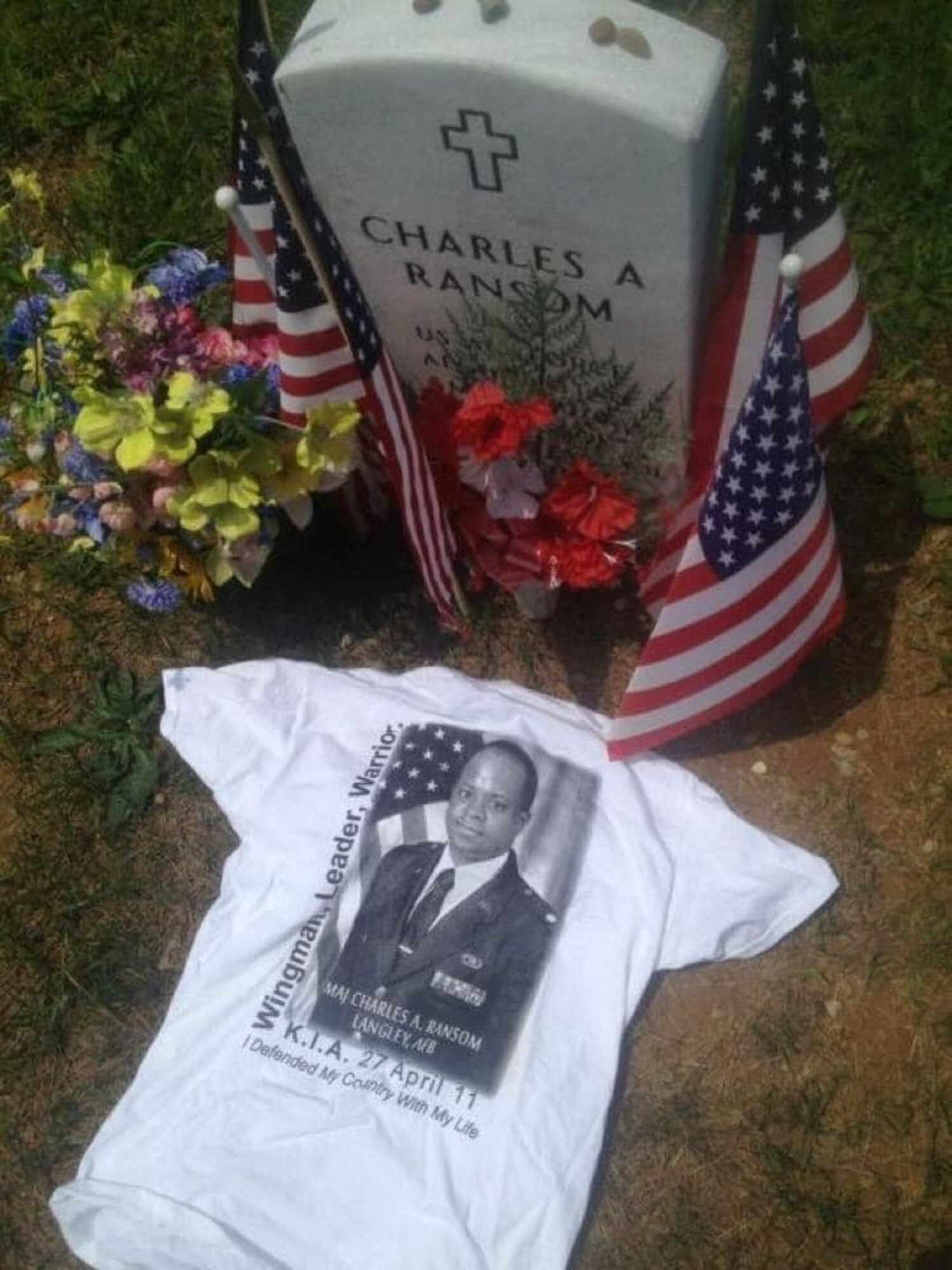 The grave of Major Charles Ransom, flight commander of plans and operations, 83rd Network Operations Squadron, is decorated with flowers, flags and a shirt that says, Wingman, Leader, Warrior, which is part of the Airman’s Creed. Ransom made the ultimate sacrifice April 27, 2011. (Courtesy photo)