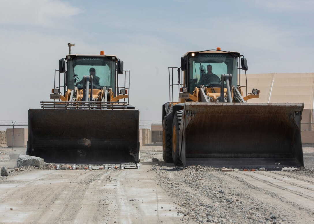 Airmen use heavy equipment to clear debris from runway.