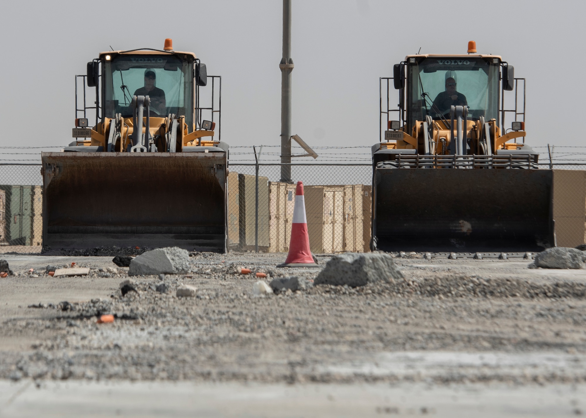 Airmen use heavy equipment to clear debris from runway.