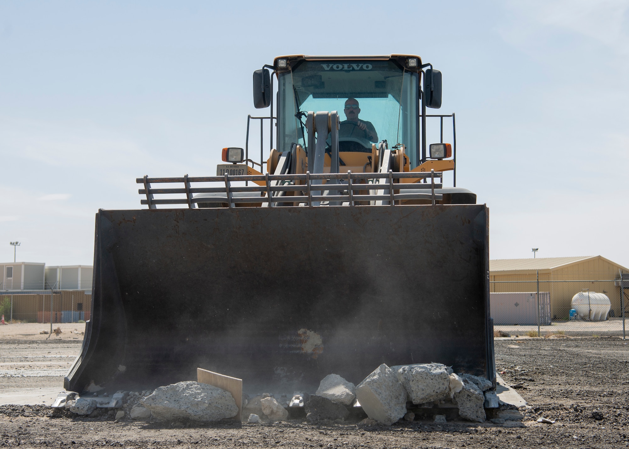 Airmen use heavy equipment to clear debris from runway.