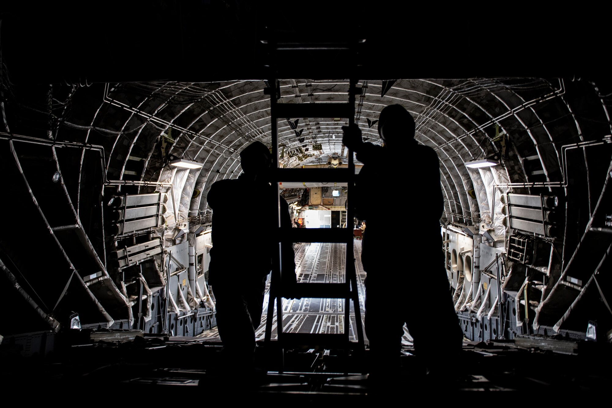 Senior Airman Zach Smith and Airman 1st Class Luke Morrow, 911th Maintenance Squadron crew chiefs, set up a ladder inside a C-17 Globemaster III during a Home Station Check inspection at the Pittsburgh International Airport Air Reserve Station, Pennsylvania, May 10, 2020.