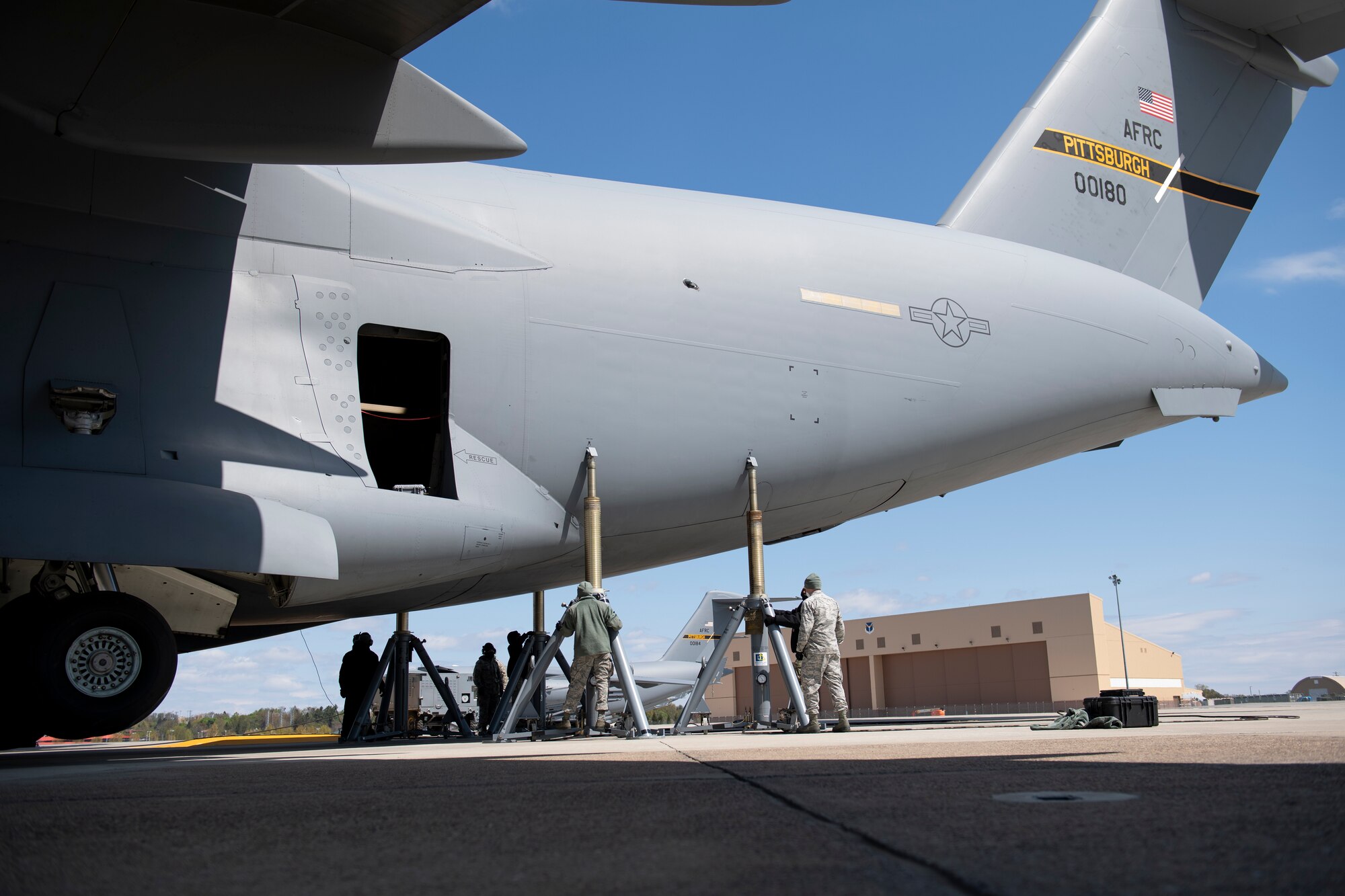 Airmen assigned to the 911th Maintenance Group lift a C-17 Globemaster III as part of a home station check inspection at the Pittsburgh International Airport Air Reserve Station, Pennsylvania, May 12, 2020.