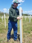 JD Lambrinos, forest program manager for the Pennsylvania Department of Military and Veterans Affairs, inspects a tree tube at Fort Indiantown Gap, Pa., on May 13, 2020.
