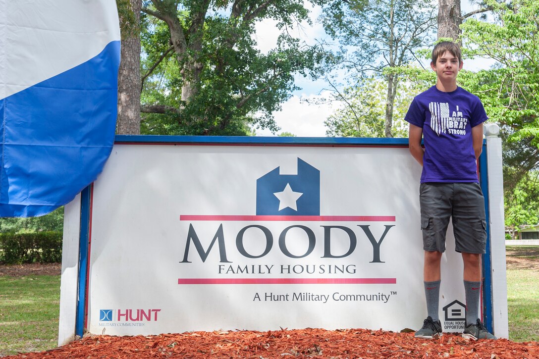 Photo of Hunt Little Heroes award winner in front of Hunt Community sign