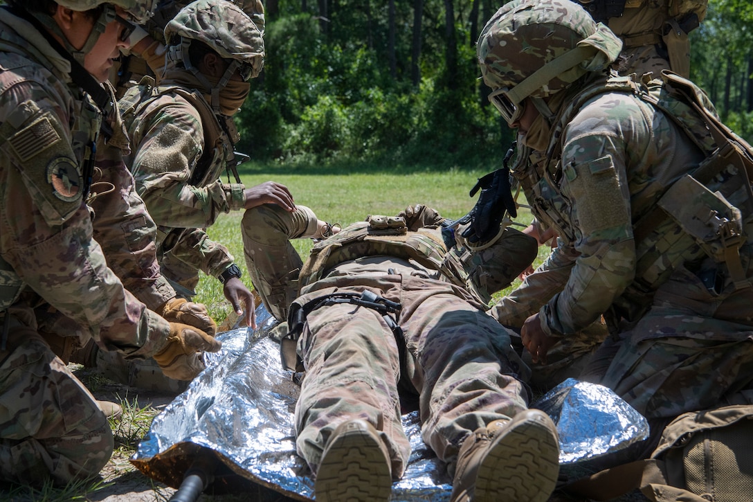 Airmen treat a patient during a training scenario