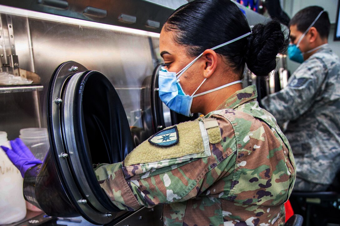 A soldier wearing a face mask conducts COVID-19 testing.