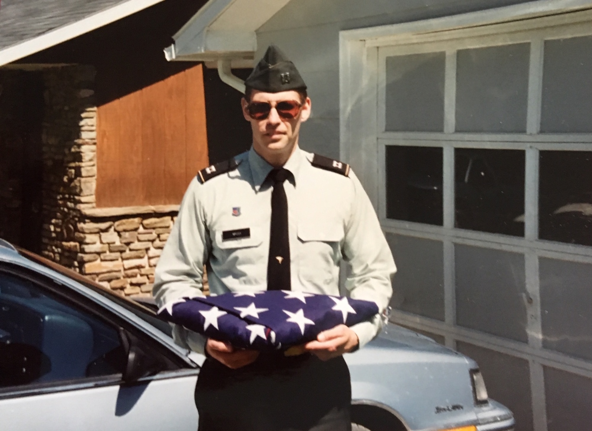 Army Capt. Robert McCoy holds a folded U.S. flag.