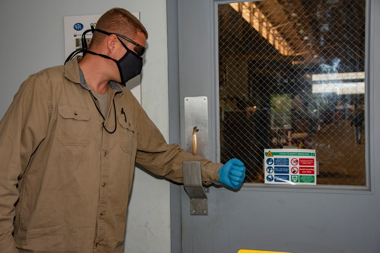 A technician using the “handle-less” door opener.