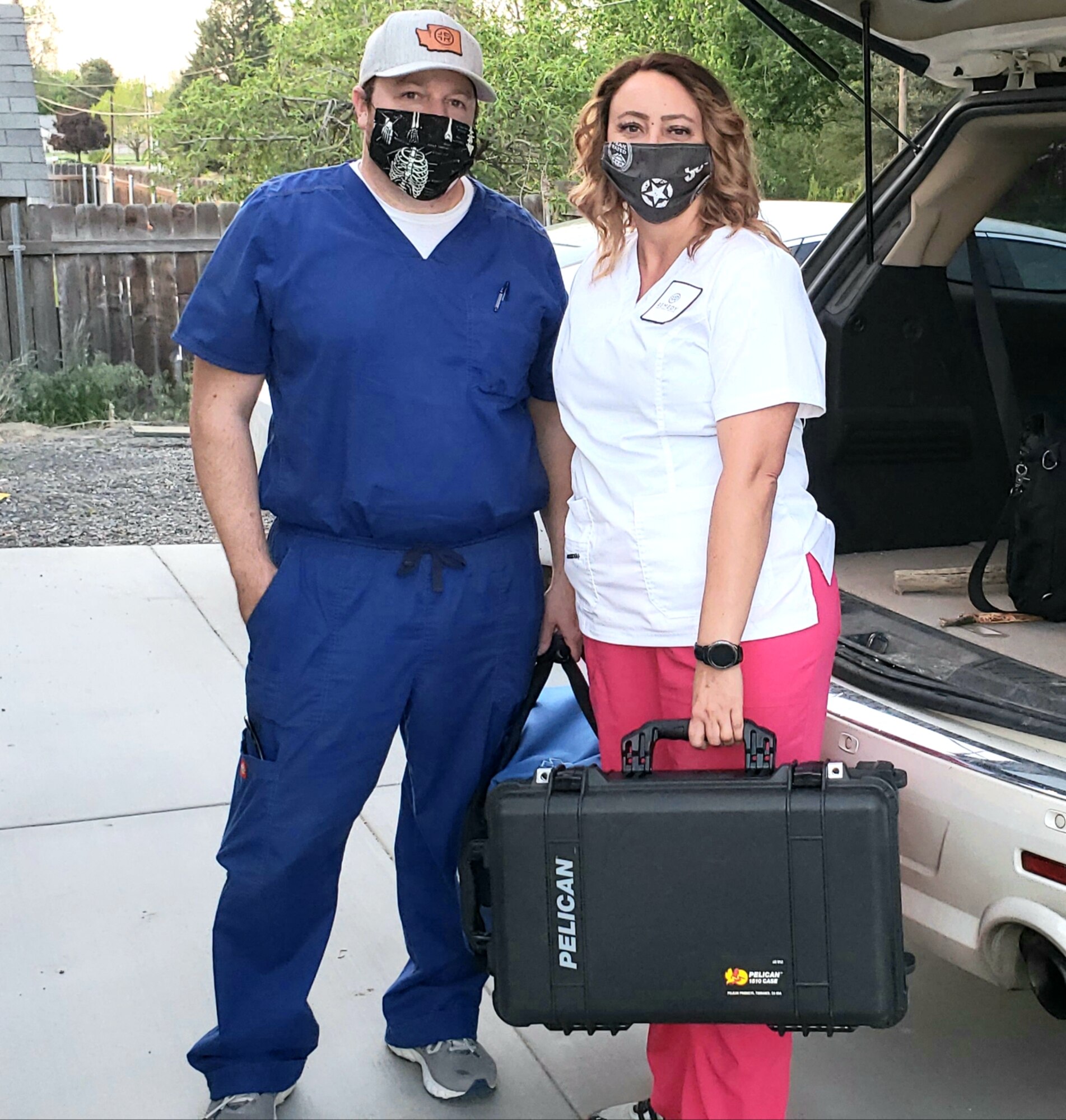 Couple pose in scrubs with face covering