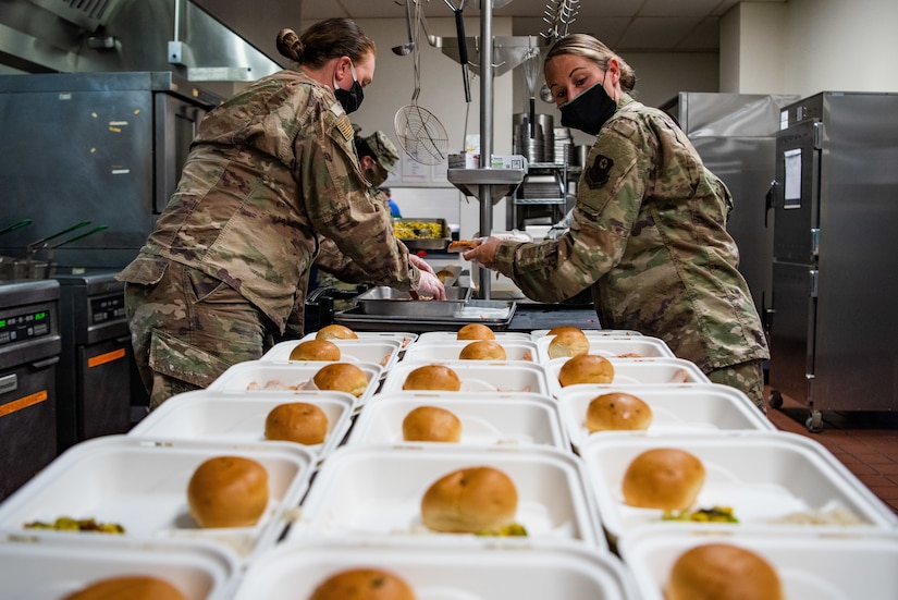 Airmen prepare meals for quarantined airmen.