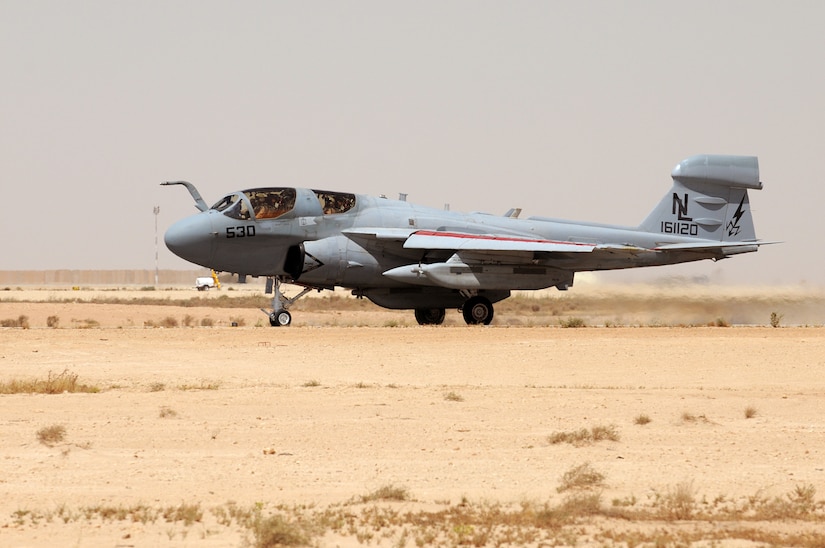 A military aircraft moves down a runway.