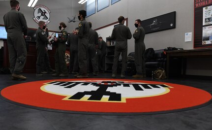 Aviators assigned to the 34th Bomb Squadron at Ellsworth Air Force Base, S.D., gather for a step briefing May 19, 2020, to receive mission plans for a long-range, long-duration Bomber Task Force mission in the U.S. European Command area of responsibility. BTF missions demonstrate the commitment of the U.S. to integrate with NATO and allied partners and ensure regional security. (U.S. Air Force photo by Airman 1st Class Christina Bennett)