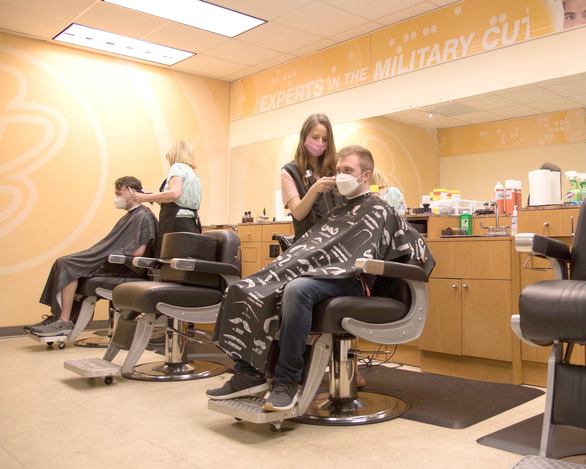 Military members receive haircuts at the Base
Exchange barbershop, May 19, 2020, at Dover Air
Force Base, Delaware. Patrons of the barbershop
are required to wear face masks and to adhere to
social distancing policies. (U.S. Air Force photo by Airman 1st  Class Faith Schaefer)