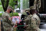 Brig. Gen. John Gentry, commander of the Marietta-based, 78th Troop Command, and Command Sgt. Maj. Paul Locke, senior enlisted adviser, meet with Cpt. Athena Brown, officer in charge, 110th Combat Sustainment Support Battalion, at Frederick Douglass High School in Atlanta, Georgia, May 18, 2020. Members of the Guard helped distribute food to children who normally would get two meals a day at school.