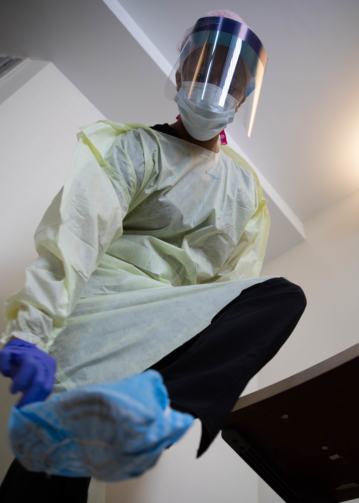 .S. Air Force Capt. Arielle Watson, assigned to the 94th Aeromedical Staging Squadron, removes personal protective equipment at Queens Hospital in Queens, N.Y., May 13, 2020.