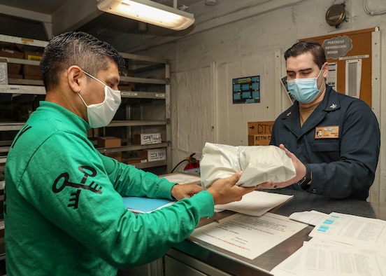 A man in face mask cleans a bus.