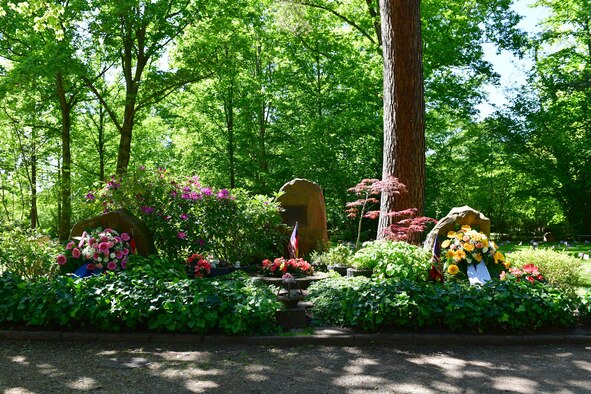 Floral wreaths sit in front of a grave site.