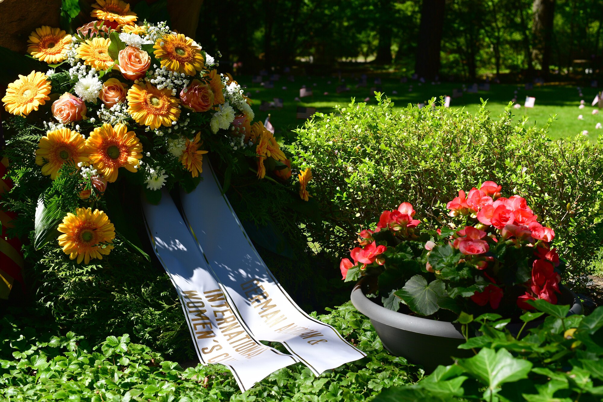 A floral wreath sits in front of a grave site.