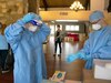 Spc Dominique Dalessio (left) and Sgt. Shane Brandes (right) adjust their face shields and personal protective equipment while preparing for the mission to administer COVID-19 tests at the Lancashire Hall Nursing and Rehab Center in Lancaster, Pa., on May 19, 2020.