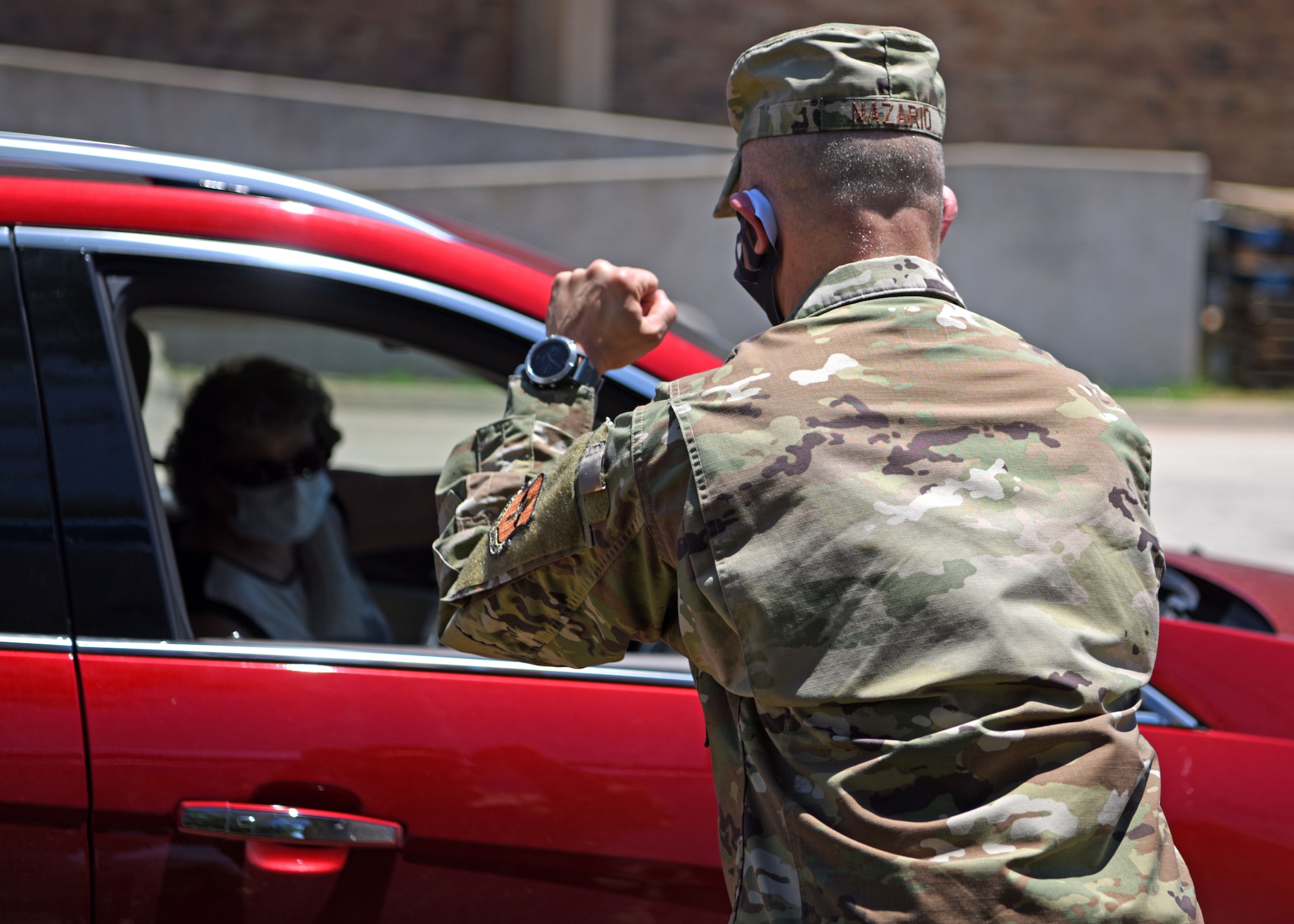 U.S. Air Force Col. Andres Nazario, 17th Training Wing commander, cheers on a retiree as she picks up her prescription from the drive thru pharmacy on Goodfellow Air Force Base, Texas, May 20, 2020. Retirees could call in their prescriptions and pick them up during certain times throughout the week. (U.S. Air Force photo by Airman 1st Class Ethan Sherwood)