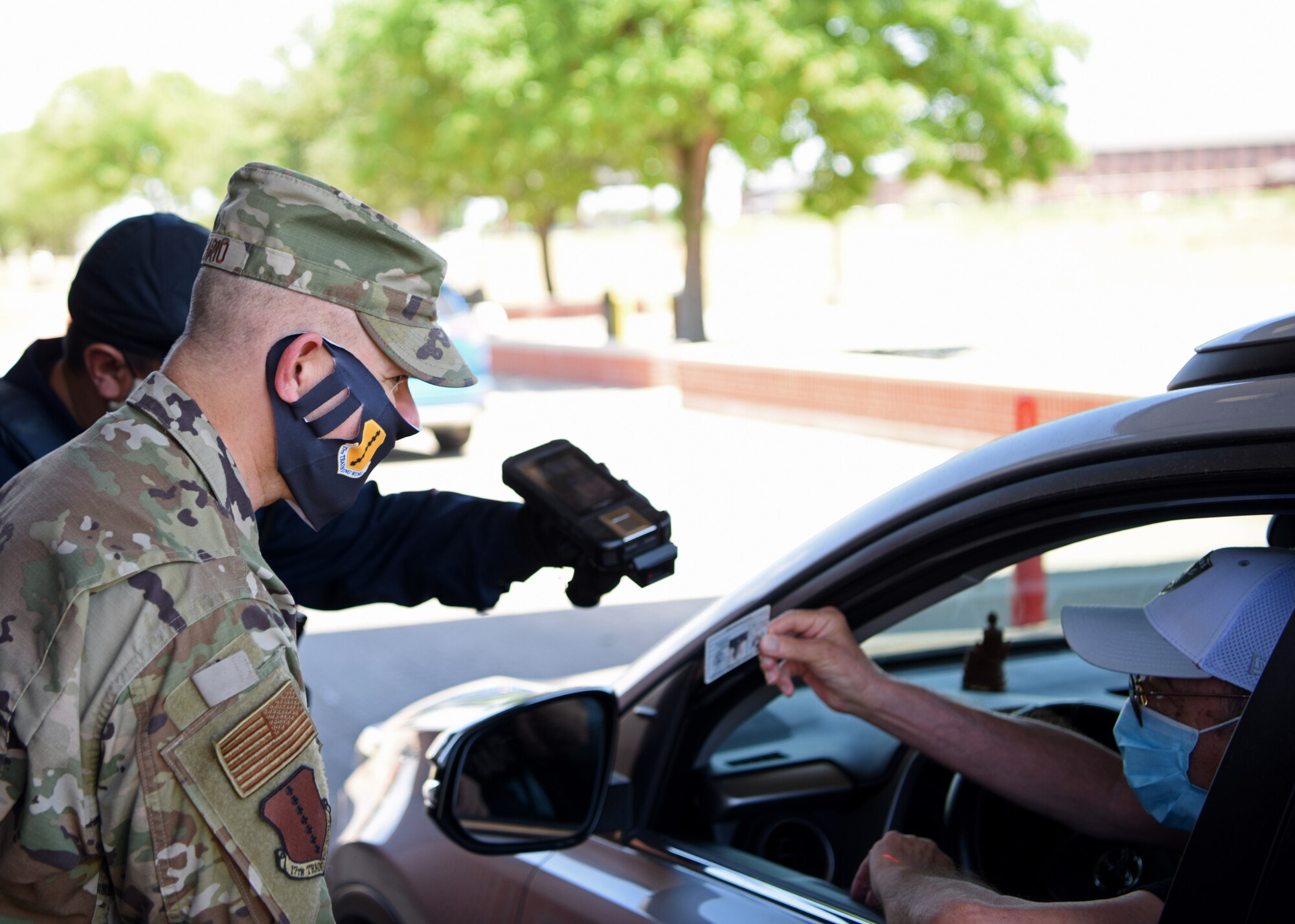 U.S. Air Force Col. Andres Nazario, 17th Training Wing commander, welcomes a retiree back on Goodfellow Air Force Base, Texas, May 20, 2020. Goodfellow was closed to retirees and their dependents temporarily to prevent the spread of COVID-19. (U.S. Air Force photo by Airman 1st Class Ethan Sherwood)