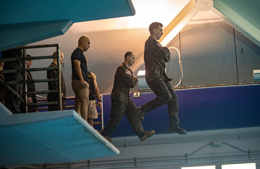 Marines and Sailors with Special Purpose Marine Air-Ground Task Force - Southern Command jump off a tower into a training pool during the basic swim qualification course, a part of the Marine Corps Water Survival Training Program, at Marine Corps Base Camp Lejeune, North Carolina, March 11, 2020. The Marine Corps Water Survival Training Program is designed to train Marines with the ability to survive in water. Marines and Sailors with SPMAGTF-SC are conducting a variety of pre-deployment training events and qualifications prior to deploying in order to enhance crisis response readiness in and around Central America, South America and the Caribbean. These events are held at Camp Lejeune and will assist the Marines and Sailors with providing security cooperation training and engineering projects alongside partner nation military forces in the Latin American and Caribbean region, as well as remaining ready to respond to crises in the event of an emergency within the region. (U.S. Marine Corps photo by Sgt. Andy O. Martinez)