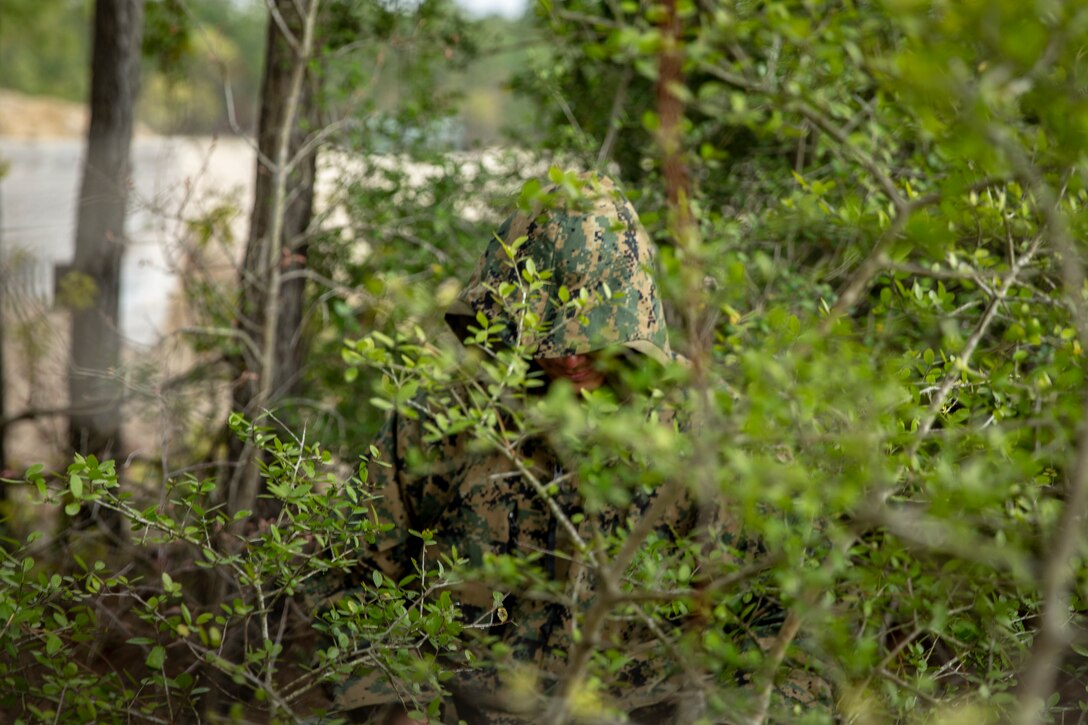 Cpl. Jonathon Duong, a landing support specialist with Special Purpose Marine Air-Ground Task Force - Southern Command, conducts radio watch during a command post exercise at Marine Corps Base Camp Lejeune, North Carolina, April 6, 2020. Duong stood his radio watch under the cover of foliage while it rained. The Marines and Sailors of SPMAGTF-SC use the training opportunity of the CPX to both show their capabilities in a controlled environment and prepare for the upcoming mission. SPMAGTF-SC is poised to conduct crisis response, theater security cooperation, and general engineering training alongside partner nation militaries in Latin America and the Caribbean. Duong is a native of San Francisco, California. (U.S. Marine Corps photo by Cpl. Benjamin D. Larsen)
