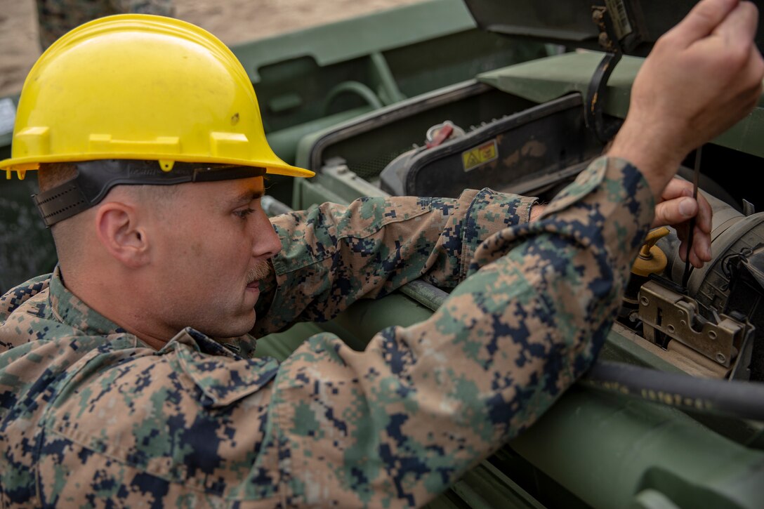 Lance Cpl. Oliver Cravens, a heavy equipment operator with Special Purpose Marine Air-Ground Task Force - Southern Command, conducts a maintenance inspection during a command post exercise at Marine Corps Base Camp Lejeune, North Carolina, April 7, 2020. Daily equipment inspections are essential to the life and dependability of machinery. The Marines and Sailors of SPMAGTF-SC use the training opportunity of the CPX to both show their capabilities in a controlled environment and prepare for the upcoming mission. SPMAGTF-SC is poised to conduct crisis response, theater security cooperation, and general engineering training alongside partner nation militaries in Latin America and the Caribbean. Cravens is a native of Portland, Oregon. (U.S. Marine Corps photo by Cpl. Benjamin D. Larsen)