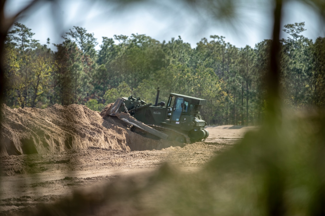 Sgt. Zack Vandehey, a heavy equipment foreman with Special Purpose Marine Air-Ground Task Force - Southern Command, creates a berm during a command post exercise at Marine Corps Base Camp Lejeune, North Carolina, April 8, 2020. The Marines and Sailors of SPMAGTF-SC use the training opportunity of the CPX to both show their capabilities in a controlled environment and prepare for the upcoming mission. SPMAGTF-SC is poised to conduct crisis response, theater security cooperation, and general engineering training alongside partner nation militaries in Latin America and the Caribbean. Vandehey is a native of Oakland, Oregon. (U.S. Marine Corps photo by Cpl. Benjamin D. Larsen)