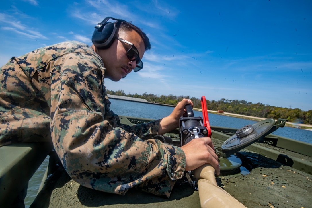 Lance Cpl. Joseph Sacco, a water support technician with Special Purpose Marine Air-Ground Task Force - Southern Command, fills a water storage container with purified water during a command post exercise at Camp Lejeune, North Carolina, April 7, 2020. The CPX increases readiness and challenges SPMAGTF-SC command and control, communications and timely decision-making capabilities through simulated real-world scenarios. SPMAGTF-SC will be deployed into the Southern Command area of operation to provide crisis response preparedness efforts, security cooperation training and engineering events to help strengthen relations with partner nations throughout Central and South America. Sacco is a native of Beaverton, Oregon. (U.S. Marine Corps photo by Sgt. Andy O. Martinez)
