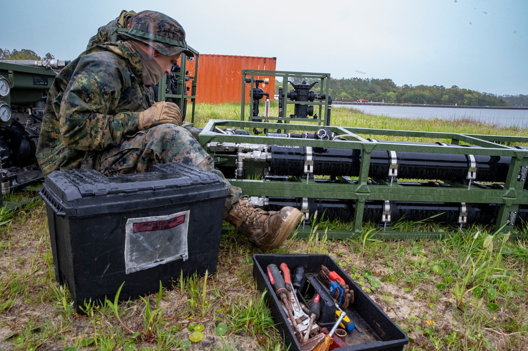 Lance Cpl. Daniel Bordenave, a water support technician with Special Purpose Marine Air-Ground Task Force - Southern Command, sets up the lightweight water purification system during a command post exercise at Camp Lejeune, North Carolina, April 10, 2020. Water support technician Marines used lightweight water purification systems to purify water before providing it to the combat engineer Marines working at another site. The CPX increases readiness and challenges SPMAGTF-SC command and control, communications and timely decision-making capabilities through simulated real-world scenarios. SPMAGTF-SC will be deployed into the Southern Command area of operation to provide crisis response preparedness efforts, security cooperation training and engineering events to help strengthen relations with partner nations throughout Central and South America.  Bordenave is a native of Pleasanton, California. (U.S. Marine Corps photo by Sgt. Andy O. Martinez)