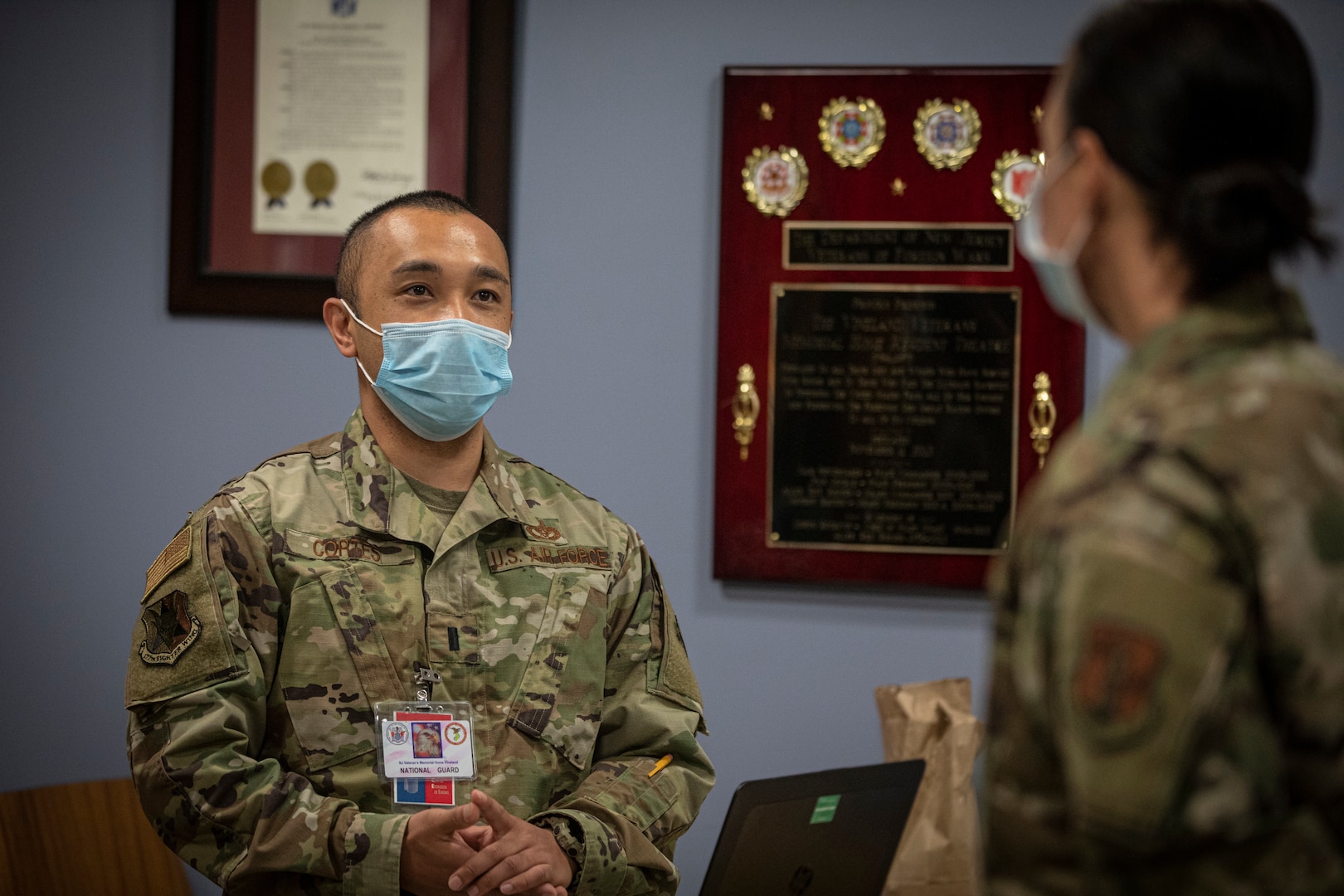 U.S. Air Force 1st Lt. Bernard Cortes, left, speaks with 108th Wing Command Chief Master Sgt. Holly Rivera at the Veterans Memorial Home at Vineland, N.J., May 19, 2020. Cortes, who is with the New Jersey National Guard’s 177th Fighter Wing, is deployed as officer in charge to the home with a team of Airmen supporting staff with housekeeping, maintenance, health screening, food service, and life enrichment.