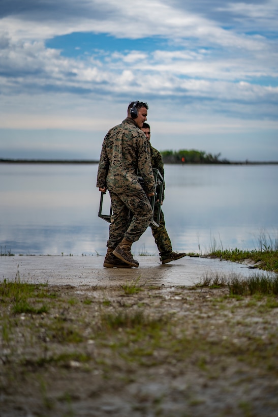 Lance Cpl. Joseph Sacco, front, and Lance Cpl. Brandon Drapela, back, water support technicians with Special Purpose Marine Air-Ground Task Force - Southern Command, carry a reverse osmosis module into position during a command post exercise at Camp Lejeune, North Carolina, April 9, 2020.  Water support technician Marines moved locations to practice setting up the lightweight water purification system on uneven ground instead of concrete. The CPX increases readiness and challenges SPMAGTF-SC command and control, communications and timely decision-making capabilities through simulated real-world scenarios. SPMAGTF-SC will be deployed into the Southern Command area of operation to provide crisis response preparedness efforts, security cooperation training and engineering events to help strengthen relations with partner nations throughout Central and South America. Sacco is a native of Beaverton, Oregon. Drapela is a native of Corvallis, Oregon. (U.S. Marine Corps photo by Sgt. Andy O. Martinez)