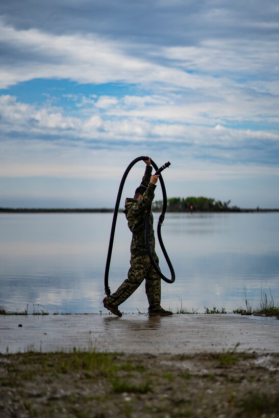 Lance Cpl. Brandon Drapela, a water support technician with Special Purpose Marine Air-Ground Task Force - Southern Command, unloads water hoses to set up a lightweight water purification system during ta command post exercise at Camp Lejeune, North Carolina, April 9, 2020. Water support technician Marines used lightweight water purification systems to purify water before providing it to the combat engineer Marines working at another site. The CPX increases readiness and challenges SPMAGTF-SC command and control, communications and timely decision-making capabilities through simulated real-world scenarios. SPMAGTF-SC will be deployed into the Southern Command area of operation to provide crisis response preparedness efforts, security cooperation training and engineering events to help strengthen relations with partner nations throughout Central and South America.  Drapela is a native of Corvallis, Oregon. (U.S. Marine Corps photo by Sgt. Andy O. Martinez)