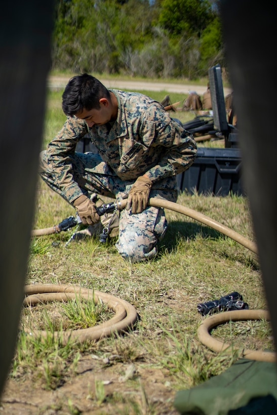 Lance Cpl. Anthony Bryan, a water support technician with Special Purpose Marine Air-Ground Task Force - Southern Command, connects water hoses together during a command post exercise at Camp Lejeune, North Carolina, April 10, 2020. Water support technician Marines used lightweight water purification systems to purify water before providing it to the combat engineer Marines working at another site. The CPX increases readiness and challenges SPMAGTF-SC command and control, communications and timely decision-making capabilities through simulated real-world scenarios. SPMAGTF-SC will be deployed into the Southern Command area of operation to provide crisis response preparedness efforts, security cooperation training and engineering events to help strengthen relations with partner nations throughout Central and South America. Bryan is a native of Eugene, Oregon. (U.S. Marine Corps photo by Sgt. Andy O. Martinez)
