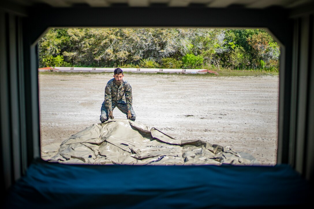 Lance Cpl. Anthony Bryan, a water support technician with Special Purpose Marine Air-Ground Task Force - Southern Command, unloads a 3,000-gallon capacity bag that holds potable water during a command post exercise at Camp Lejeune, North Carolina, April 10, 2020. Water support technician Marines used lightweight water purification systems to purify water before providing it to the combat engineer Marines working at another site. The CPX increases readiness and challenges SPMAGTF-SC command and control, communications and timely decision-making capabilities through simulated real-world scenarios. SPMAGTF-SC will be deployed into the Southern Command area of operation to provide crisis response preparedness efforts, security cooperation training and engineering events to help strengthen relations with partner nations throughout Central and South America. Bryan is a native of Eugene, Oregon. (U.S. Marine Corps photo by Sgt. Andy O. Martinez)