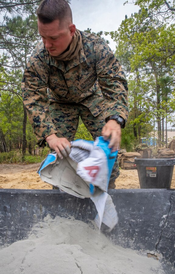 Lance Cpl. Cody Canada, a combat engineer with Special Purpose Marine Air-Ground Task Force - Southern Command, prepares a bag of mortar for mixture during a general exercise at Camp Lejeune, North Carolina, April 13, 2020. Combat engineer Marines are increasing their construction skills in preparation for infrastructure improvement projects scheduled during their upcoming deployment to Latin America. The GENEX includes training events such as engineering projects and evacuation control center training scenarios that will help build the SPMAGTF-SC for their final certification exercise. These training events also provide the Marines and Sailors with real-world scenarios to prepare them for their deployment to assist partner nation militaries in Latin America and the Caribbean. Canada is a native of Tacoma, Washington. (U.S. Marine Corps photo by Sgt. Andy O. Martinez)