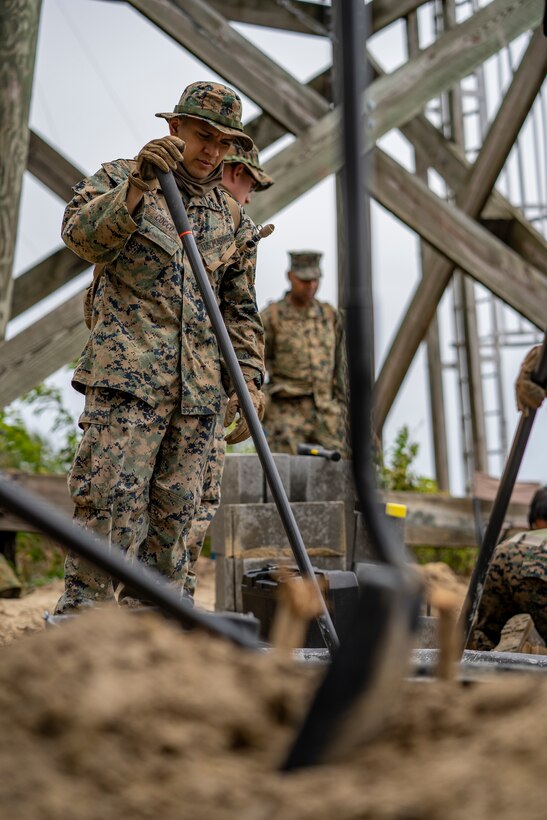 Pfc. Theo Cocco, a combat engineer with Special Purpose Marine Air-Ground Task Force - Southern Command, mixes together mortar and water during a general exercise at Camp Lejeune, North Carolina, April 13, 2020. Combat engineer Marines are increasing their construction skills in preparation for infrastructure improvement projects scheduled during their upcoming deployment to Latin America. The GENEX includes training events such as engineering projects and evacuation control center training scenarios that will help build the SPMAGTF-SC for their final certification exercise. These training events also provide the Marines and Sailors with real-world scenarios to prepare them for their deployment to assist partner nation militaries in Latin America and the Caribbean. Cocco is native of Portland, Oregon. (U.S. Marine Corps photo by Sgt. Andy O. Martinez)