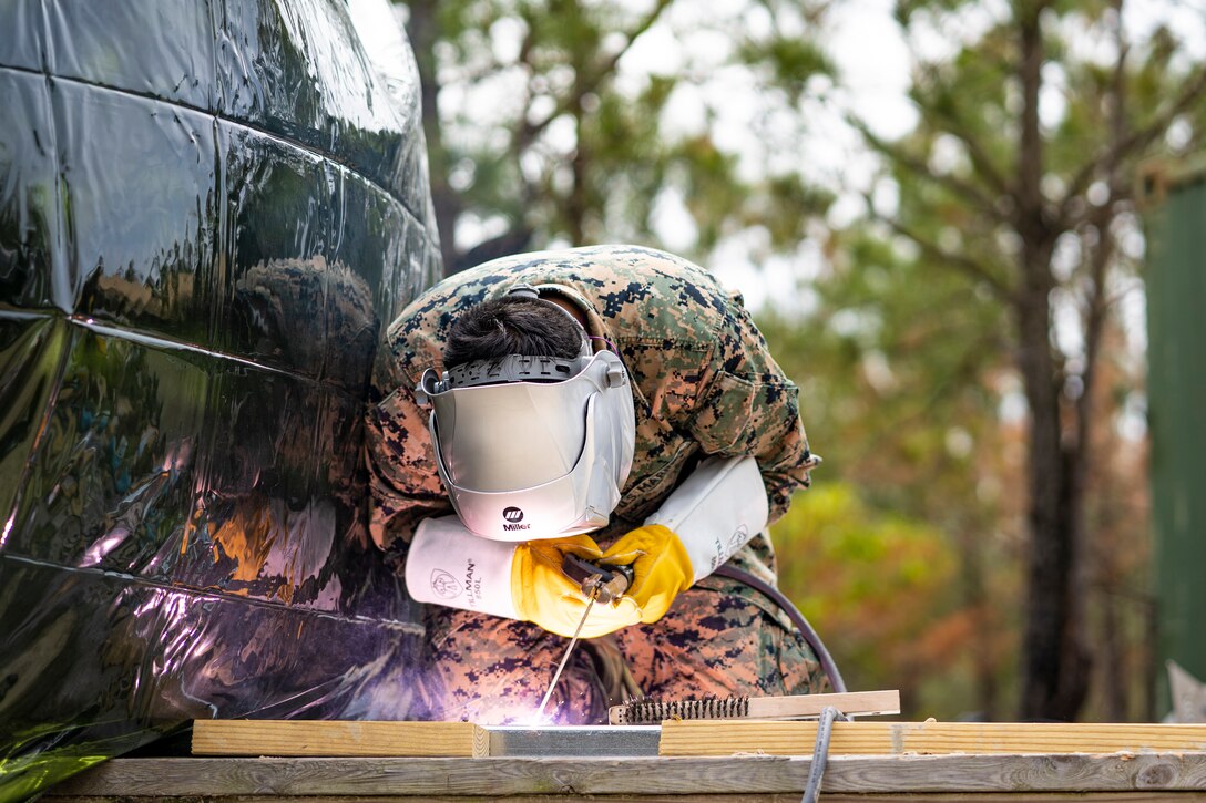 Cpl. Ricardo Torres Vasquez, a metal worker with Special Purpose Marine Air-Ground Task Force - Southern Command, tacks together metal boards during a general exercise at Camp Lejeune, North Carolina, April 13, 2020. Combat engineer Marines are increasing their construction skills in preparation for infrastructure improvement projects scheduled during their upcoming deployment to Latin America. The GENEX includes training events such as engineering projects and evacuation control center training scenarios that will help build the SPMAGTF-SC for their final certification exercise. These training events also provide the Marines and Sailors with real-world scenarios to prepare them for their deployment to assist partner nation militaries in Latin America and the Caribbean. Torres Vasquez is a native of Forest Grove, Oregon. (U.S. Marine Corps photo by Sgt. Andy O. Martinez)