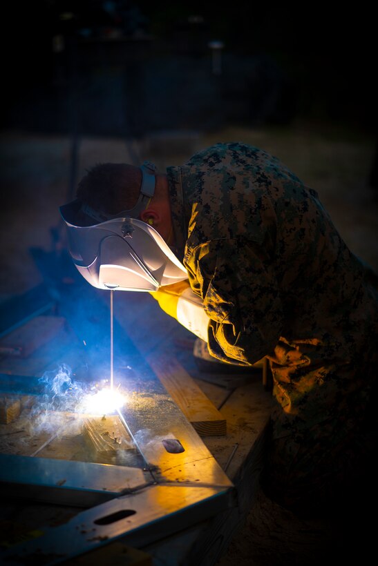 Lance Cpl. Mason Sloan, a metal worker with Special Purpose Marine Air-Ground Task Force - Southern Command, tacks metal boards together during a general exercise at Camp Lejeune, North Carolina, April 13, 2020. Engineer Marines are increasing their construction skills in preparation for infrastructure improvement projects scheduled during their upcoming deployment to Latin America. The GENEX includes training events such as engineering projects and evacuation control center training scenarios that will help build the SPMAGTF-SC for their final certification exercise. These training events also provide the Marines and Sailors with real-world scenarios to prepare them for their deployment to assist partner nation militaries in Latin America and the Caribbean. Sloan is from Halsey, Oregon. (U.S. Marine Corps photo by Sgt. Andy O. Martinez)