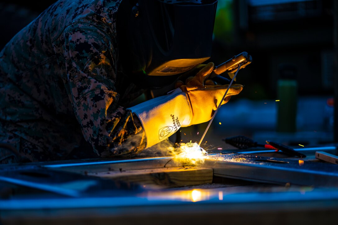 Cpl. Ricardo Torres Vasquez, a metal worker with Special Purpose Marine Air-Ground Task Force - Southern Command, tacks together metal boards during a general exercise at Camp Lejeune, North Carolina, April 13, 2020. Combat engineer Marines are increasing their construction skills in preparation for infrastructure improvement projects scheduled during their upcoming deployment to Latin America. The GENEX includes training events such as engineering projects and evacuation control center training scenarios that will help build the SPMAGTF-SC for their final certification exercise. These training events also provide the Marines and Sailors with real-world scenarios to prepare them for their deployment to assist partner nation militaries in Latin America and the Caribbean. Torres Vasquez is a native of Forest Grove, Oregon. (U.S. Marine Corps photo by Sgt. Andy O. Martinez)