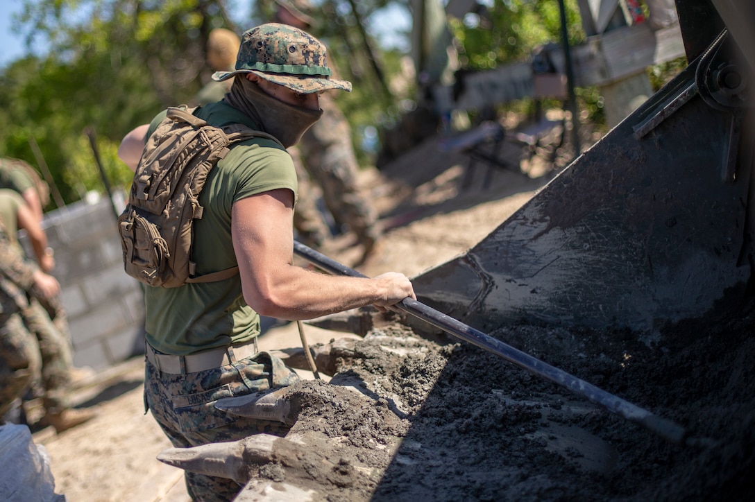 Lance Cpl. Jess Lucas, a combat engineer with Special Purpose Marine Air-Ground Task Force - Southern Command, mixes concrete during a general exercise at Marine Corps Base Camp Lejeune, North Carolina, April 14, 2020. The concrete was then added to the cylinder block wall to increase its strength and longevity. The GENEX includes training events such as engineering projects and evacuation control center training scenarios that will help build the SPMAGTF-SC for their final certification exercise. These training events also provide the Marines and Sailors with real-world scenarios to prepare them for their deployment to assist partner nation militaries in Latin America and the Caribbean. Lucas is a native of Forest Grove, Oregon. (U.S. Marine Corps photo by Cpl. Benjamin D. Larsen)